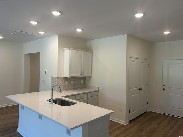 kitchen with a peninsula, white cabinetry, light countertops, and a sink