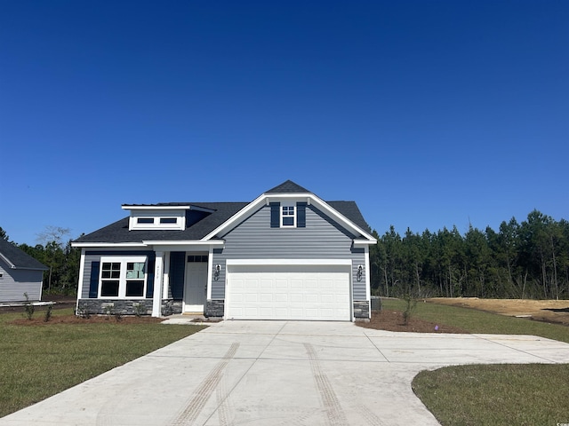 view of front of house with driveway, stone siding, a garage, and a front yard