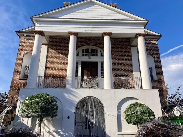 doorway to property with brick siding and a balcony