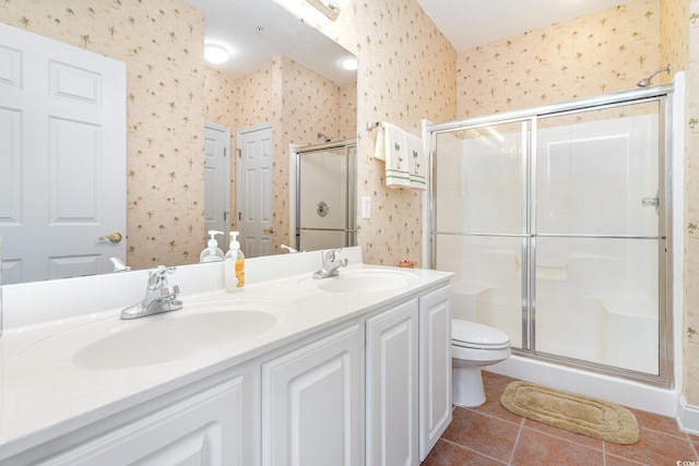 bathroom with vanity, a shower with shower door, toilet, and tile patterned flooring