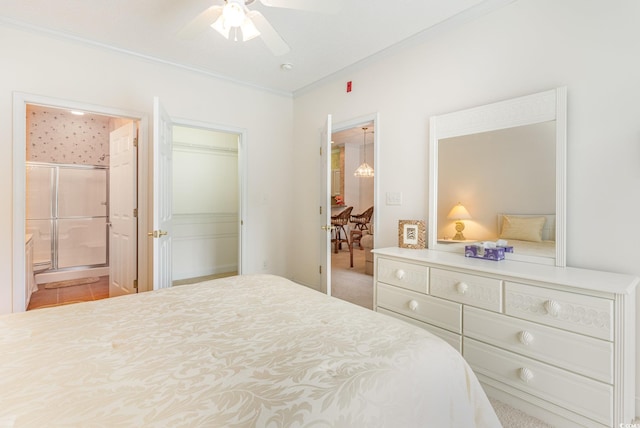 carpeted bedroom featuring ensuite bathroom, crown molding, ceiling fan, and a closet