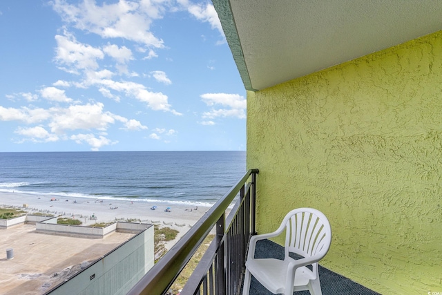 balcony with a water view and a view of the beach