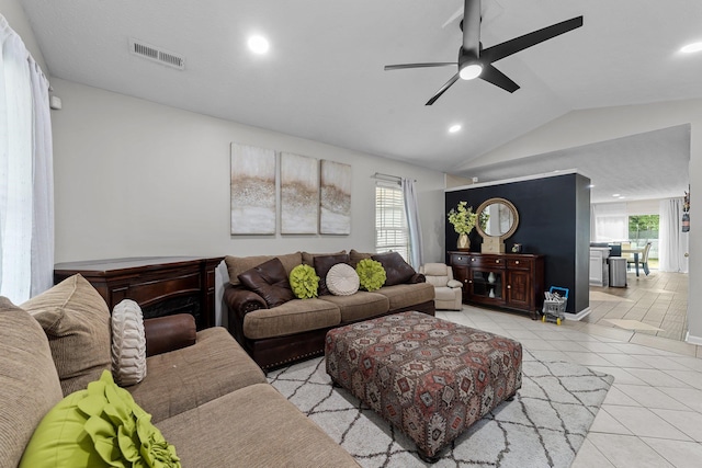 living room featuring lofted ceiling, ceiling fan, and light tile patterned floors