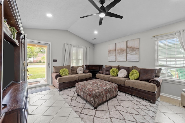 tiled living room featuring ceiling fan, a healthy amount of sunlight, a textured ceiling, and vaulted ceiling