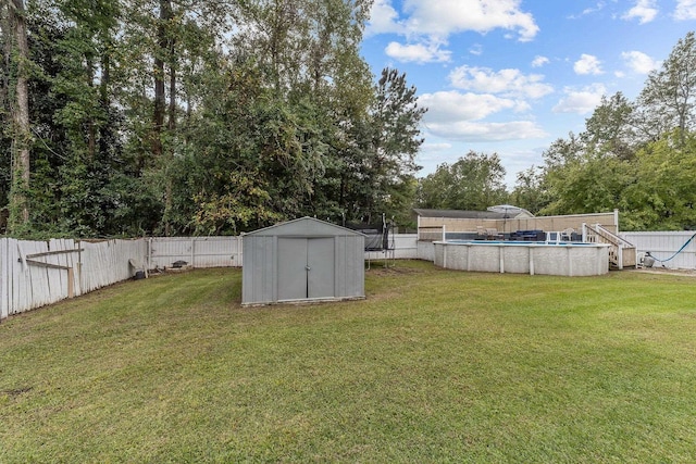 view of yard featuring a fenced in pool and a storage unit