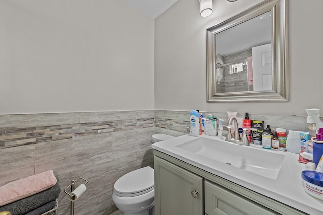 bathroom featuring tile walls, vanity, and toilet