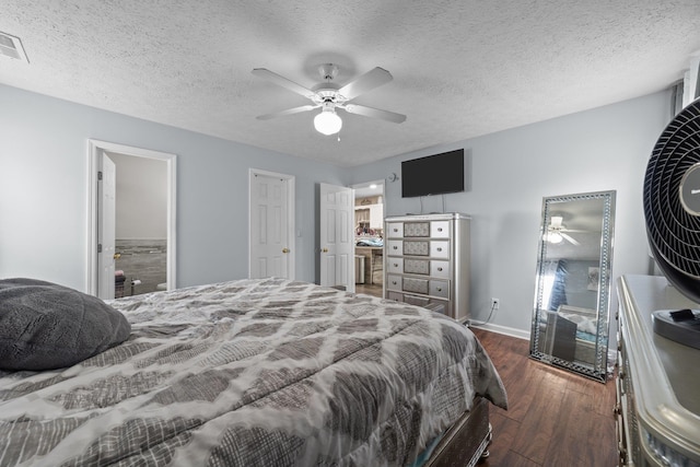 bedroom featuring dark wood-type flooring, ceiling fan, ensuite bath, and a textured ceiling