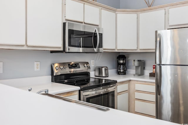 kitchen featuring stainless steel appliances and white cabinetry