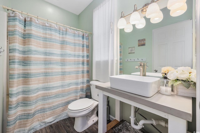 bathroom featuring walk in shower, sink, hardwood / wood-style floors, and toilet