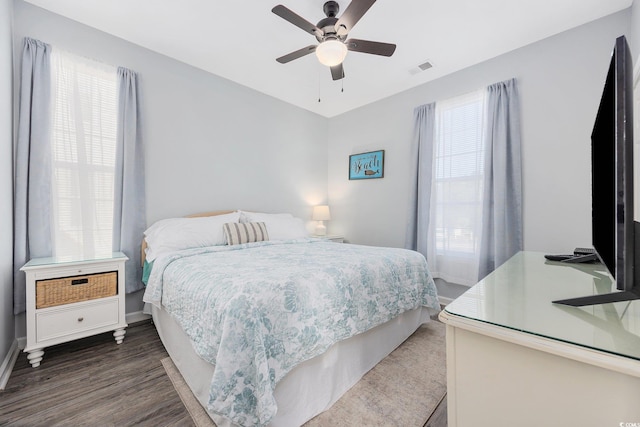 bedroom with dark hardwood / wood-style flooring and ceiling fan