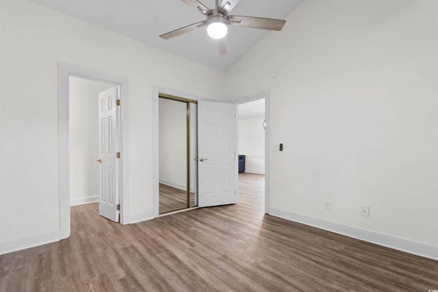 unfurnished bedroom featuring wood-type flooring, a closet, high vaulted ceiling, and ceiling fan