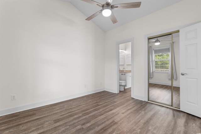 unfurnished bedroom featuring lofted ceiling, sink, ceiling fan, connected bathroom, and a closet