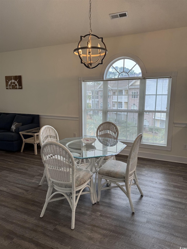 dining room with an inviting chandelier and dark wood-type flooring