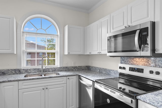 kitchen featuring white cabinets, stainless steel appliances, crown molding, and sink