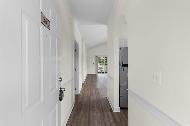 hall with dark hardwood / wood-style flooring, ornamental molding, and vaulted ceiling