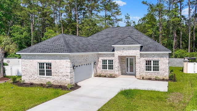 205 Waterfall Cir, Little River, SC 29566 - french country home featuring an attached garage, brick siding, a shingled roof, and driveway