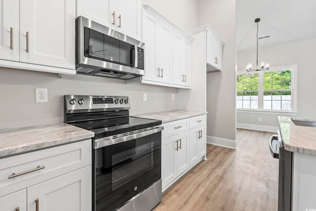 205 Waterfall Cir, Little River, SC 29566 - kitchen with appliances with stainless steel finishes, a chandelier, light wood-type flooring, white cabinets, and baseboards