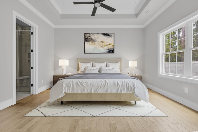 205 Waterfall Cir, Little River, SC 29566 - bedroom featuring a tray ceiling, wood finished floors, ensuite bathroom, ornamental molding, and a ceiling fan