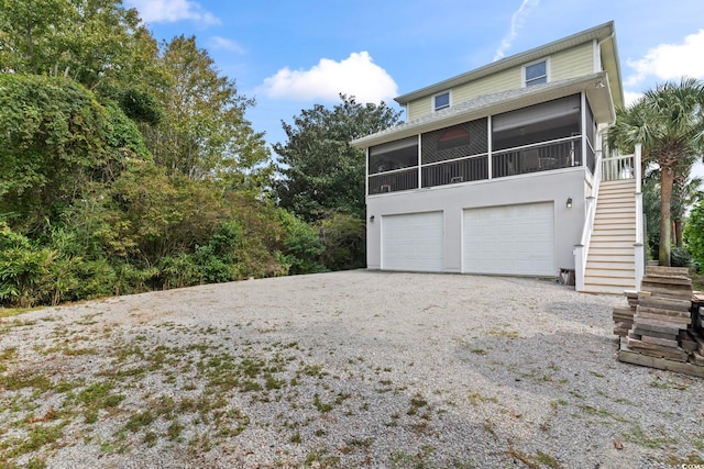 exterior space with a garage and a sunroom