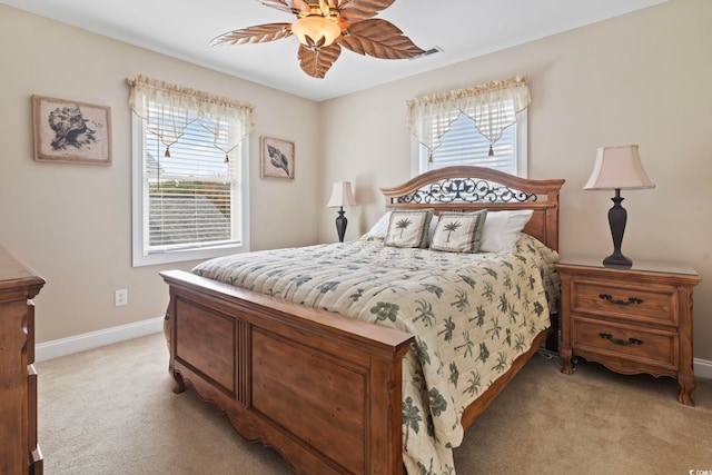 bedroom with light carpet, multiple windows, baseboards, and ceiling fan