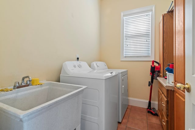 laundry room featuring baseboards, tile patterned flooring, washer and clothes dryer, laundry area, and a sink