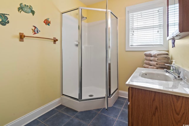 bathroom with tile patterned floors, a stall shower, baseboards, and vanity