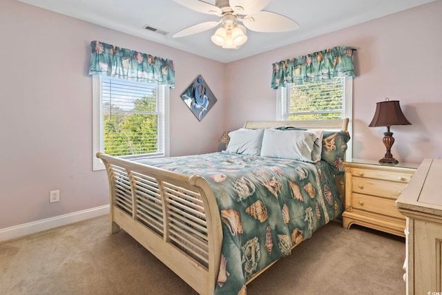 bedroom featuring light carpet, visible vents, baseboards, and ceiling fan