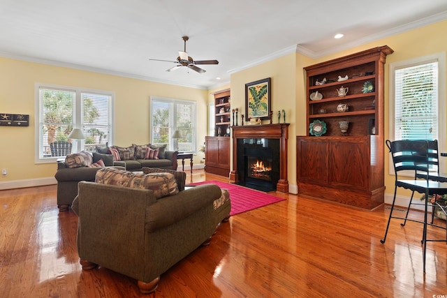 living room featuring ceiling fan, crown molding, hardwood / wood-style floors, and built in shelves