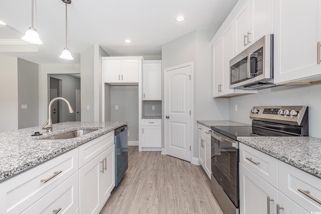 kitchen with sink, hanging light fixtures, stainless steel appliances, white cabinets, and light wood-type flooring