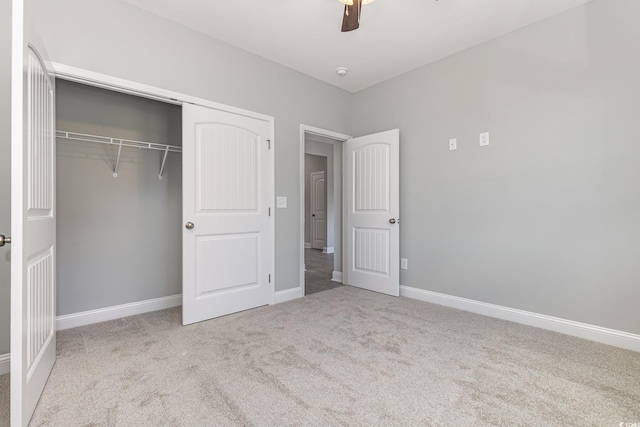 unfurnished bedroom with ceiling fan, light colored carpet, and a closet