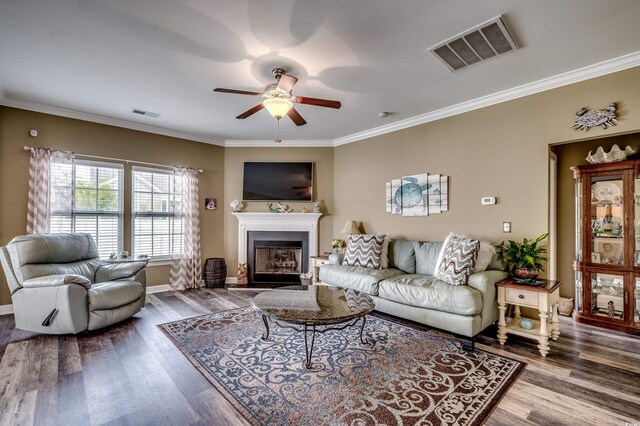 living room with ceiling fan, hardwood / wood-style flooring, and ornamental molding