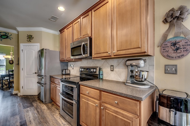 kitchen with stainless steel appliances, dark hardwood / wood-style floors, ornamental molding, and tasteful backsplash