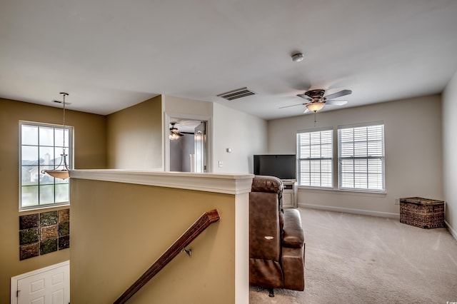 sitting room featuring plenty of natural light, light colored carpet, and ceiling fan