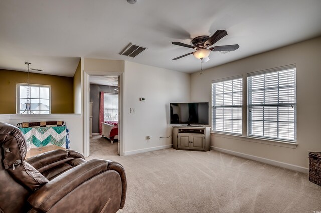 living room featuring plenty of natural light, light colored carpet, and ceiling fan