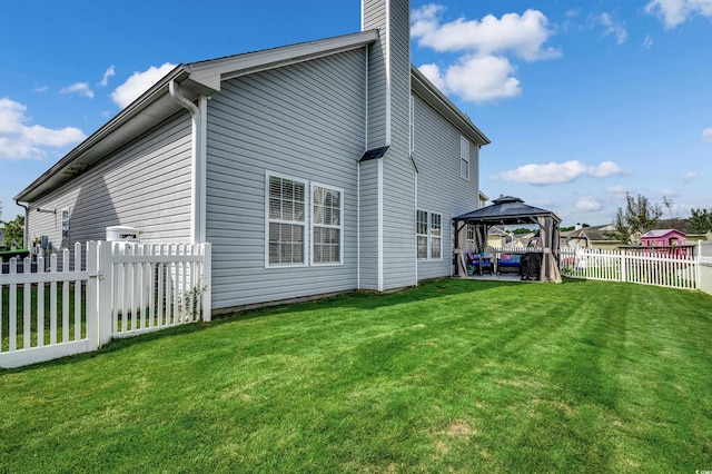 back of property featuring a gazebo, a patio, and a lawn