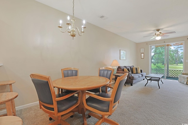 carpeted dining space with ceiling fan with notable chandelier