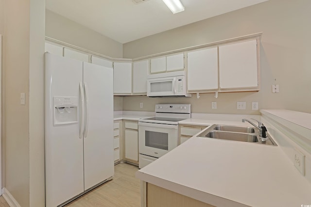 kitchen featuring white appliances, light hardwood / wood-style flooring, sink, kitchen peninsula, and white cabinets