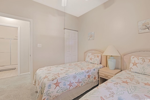 bedroom with a closet, vaulted ceiling, carpet, and ceiling fan