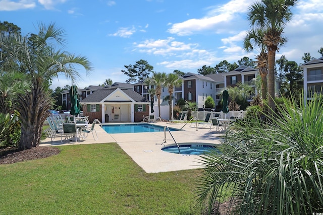 view of swimming pool with a community hot tub, a patio, and a lawn