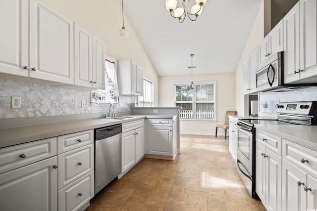 kitchen with decorative backsplash, stainless steel appliances, decorative light fixtures, white cabinetry, and lofted ceiling