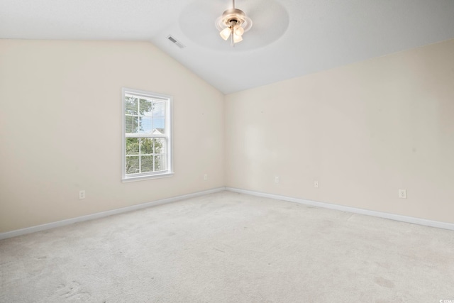 empty room with ceiling fan, light colored carpet, and vaulted ceiling