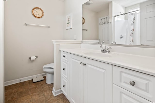 bathroom featuring walk in shower, vanity, and toilet