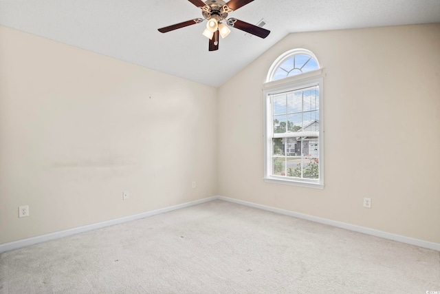 spare room featuring light colored carpet, a wealth of natural light, lofted ceiling, and ceiling fan