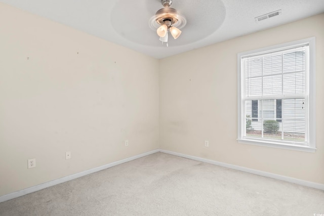 carpeted spare room with a textured ceiling and ceiling fan