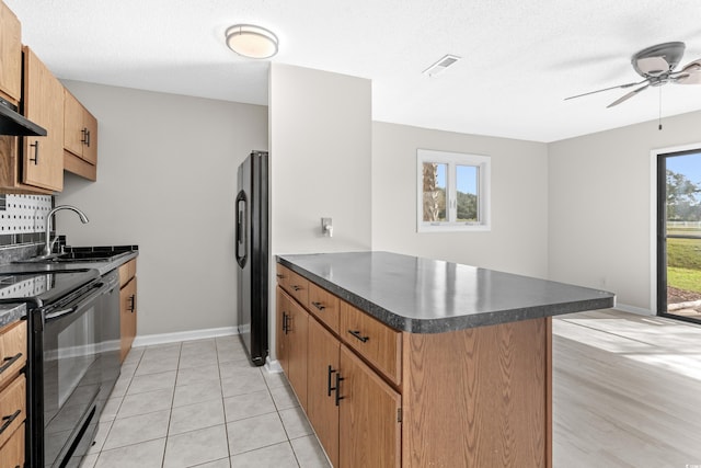 kitchen with sink, kitchen peninsula, a textured ceiling, light tile patterned flooring, and black appliances