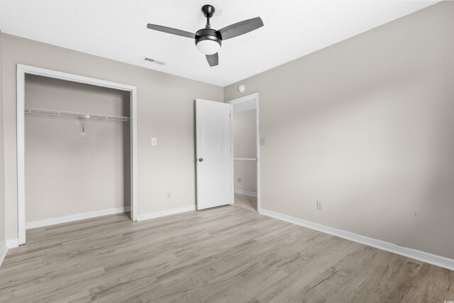 unfurnished bedroom with a closet, light hardwood / wood-style flooring, and ceiling fan