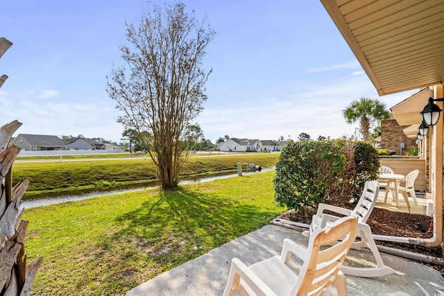 view of yard featuring a water view and a patio