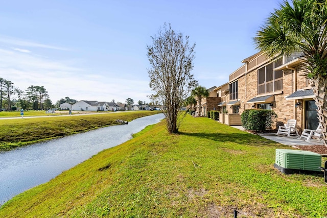 surrounding community with a water view and a yard