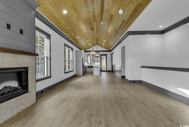 unfurnished living room with a stone fireplace, light hardwood / wood-style flooring, vaulted ceiling, a notable chandelier, and wood ceiling