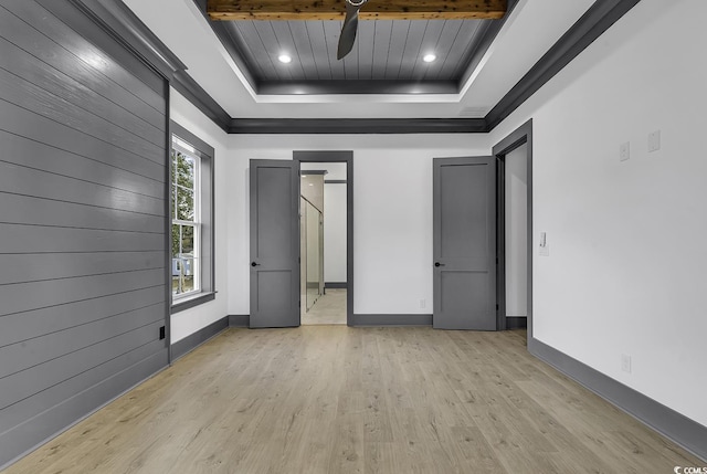 unfurnished bedroom with light hardwood / wood-style floors and a tray ceiling